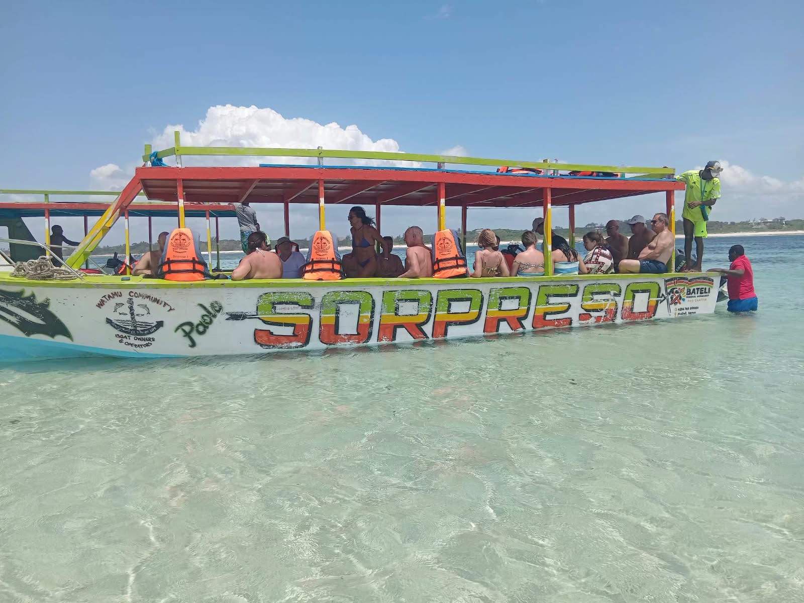 Guests on a traditional dhow-style boat in the turquoise waters off Watamu